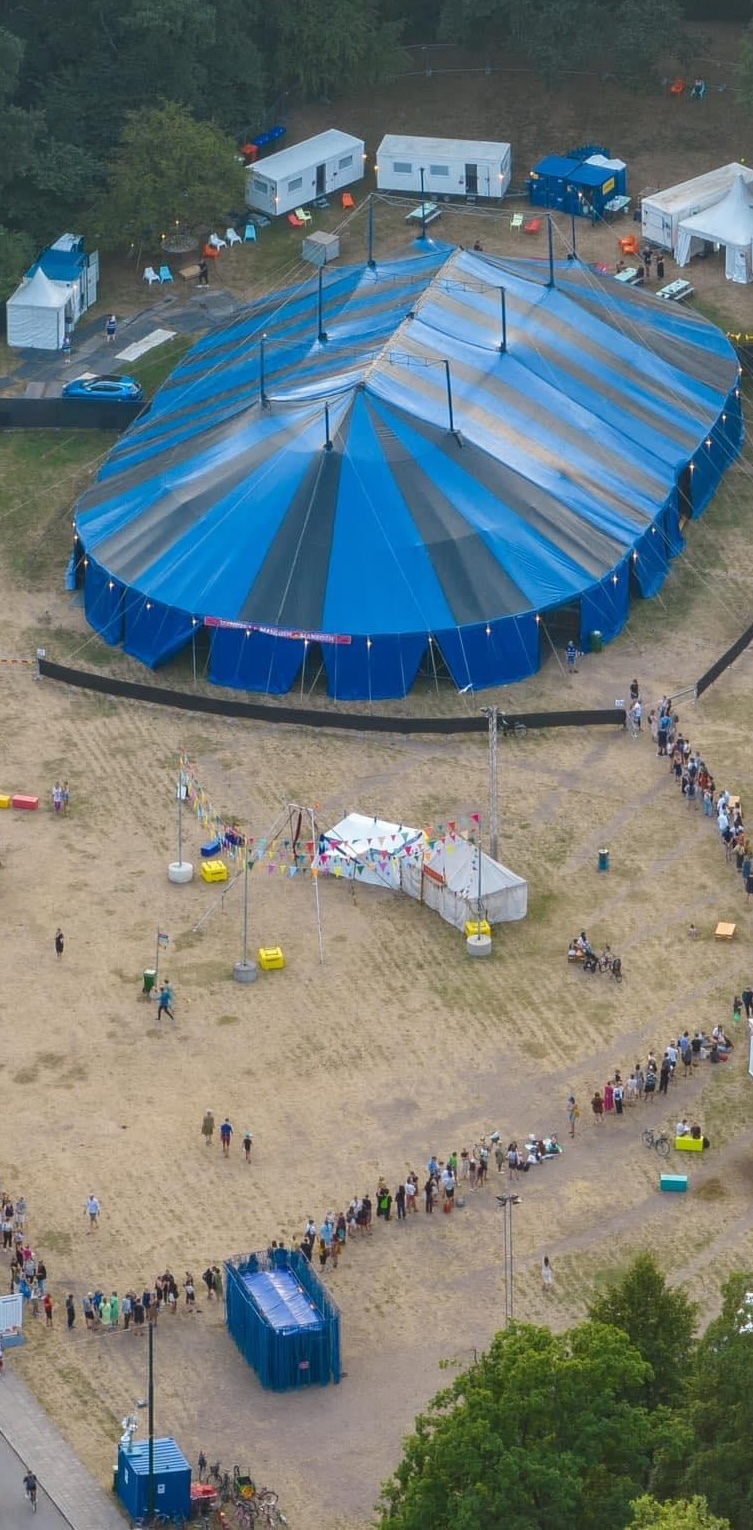 Cirkustält från ovan med kö av besökare